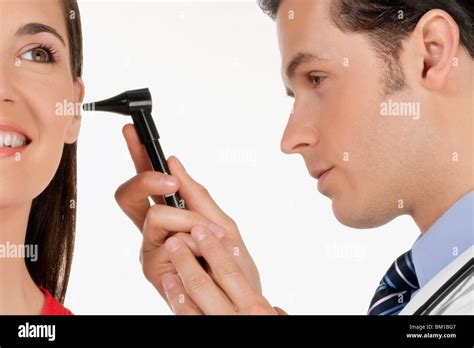 Doctor Checking A Womans Ear With An Otoscope Stock Photo Alamy