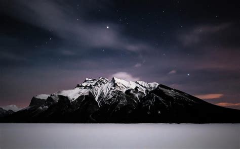 Starry Sky Over A Snow Capped Mt Girouard And A Frozen Snow Covered