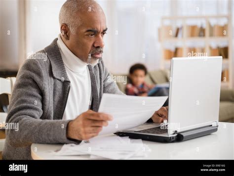 Mixed Race Man Paying Bills On Laptop Stock Photo Alamy
