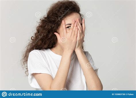 Sly Girl Hiding Face Behind Hands Peeps Through Fingers Stock Photo