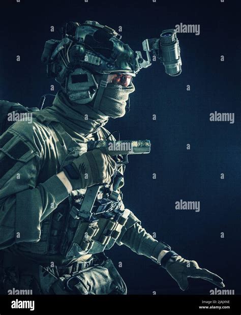 soldier wearing combat helmet mask and glasses quietly sneaking darkness with handgun in hand