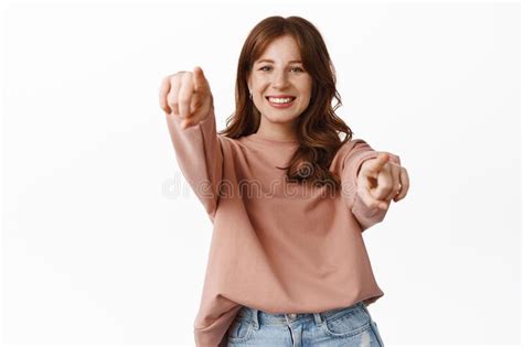portrait of happy redhead girl choosing you pointing fingers at camera and smiling inviting to