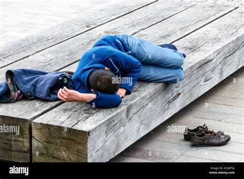 A Young Man Taking An Afternoon Nap On A Wooden Bench At Kings Cross
