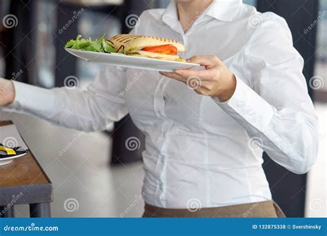 The Waitress Is Carrying A Plate Of Food To The Client Stock Photo