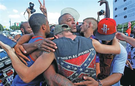 People Including A Man Wearing A Confederate Flag Hug