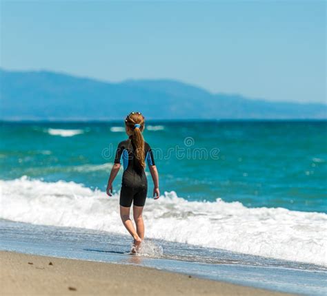 girl in a wetsuit running along the beach stock image image of lifestyles cheerful 169569453