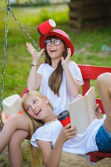 Joyful Girlfriends Having Fun On Swing Outdoor Friendship Concept