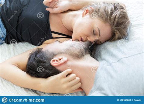 Lovely Happy Couple In Love, Smile, And Kiss Each Other On Their Bed In The Bedroom Stock Photo ...