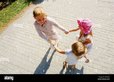Three Young Girls Playing Ring Around The Rosy Stock Photo Alamy
