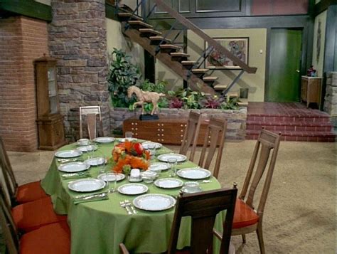 A Table With Plates And Silverware Is Set Up In Front Of The Staircase