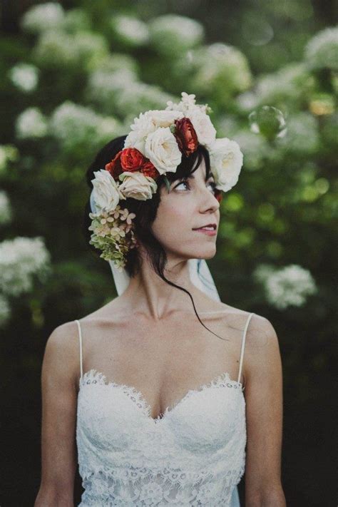A Woman With Flowers In Her Hair Wearing A Wedding Dress And Flower