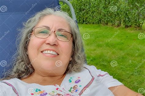 Self Portrait Of Smiling Face Of A Beautiful Chubby Mexican Woman Sitting On A Sunbathing Chair