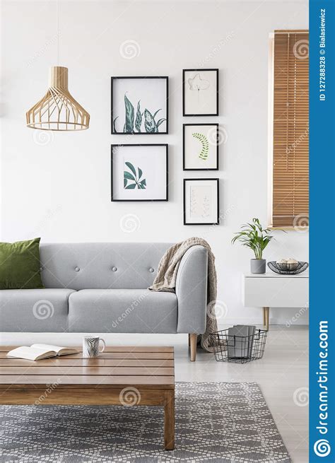 Posters On A Wall In A Living Room Interior With A Sofa And Low Coffee