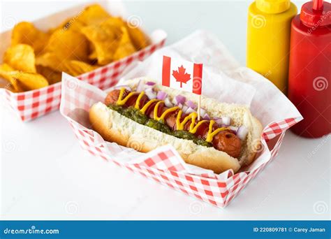 A Hotdog With A Canada Flag Pick Served With Potato Chips And A Bottle