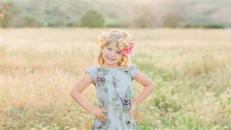 Смайлик милая маленькая девочка стоит в размытие зеленой травы поле