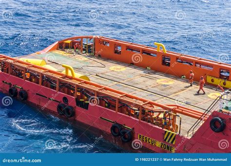 Offshore Workers Or Riggers Assisting Placement Of Anchor Buoy On Deck