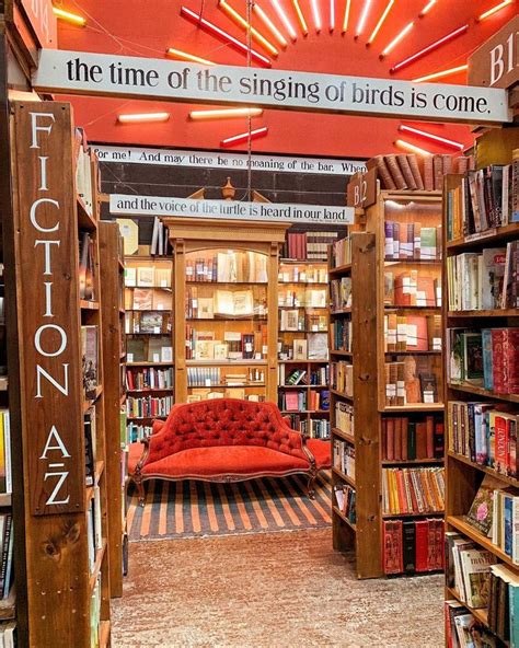 The Inside Of A Book Store With Lots Of Books On Shelves And A Red Couch