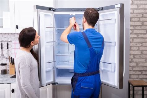 Repairman Fixing Refrigerator With Screwdriver Norman Appliance Repair