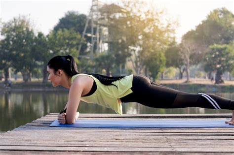 Premium Photo Young Beautiful Asian Woman In Sports Outfits Planking In The Park In The