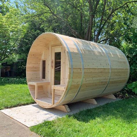 A Wooden Barrel Shaped Sauna Sitting In The Grass