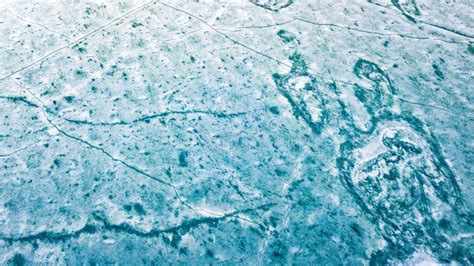 Blue Ice Surface Of Frozen Lake From Drone Aerial View Stock Photo