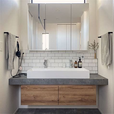 a bathroom with a sink mirror and towel rack on the counter top in front of it