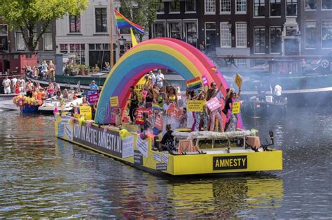holding a billboard on the amnesty international boat on the at the gaypride canal parade with