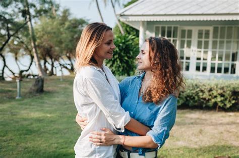 position lesbienne heureuse de couples sur la terrasse leur maison de campagne photo stock