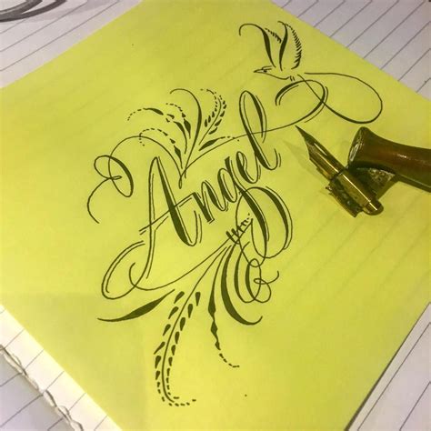 An Ink Pen Is Laying On Top Of A Piece Of Paper With The Word Angel
