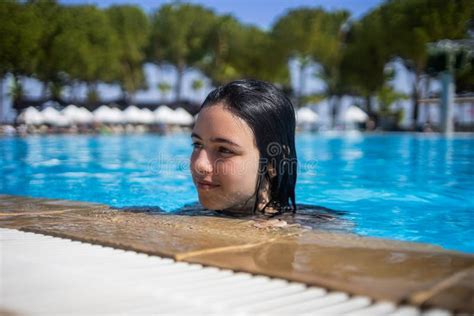 Young Brunette Teen Girl Posing In A Blue Swimming Pool In A Hotel In