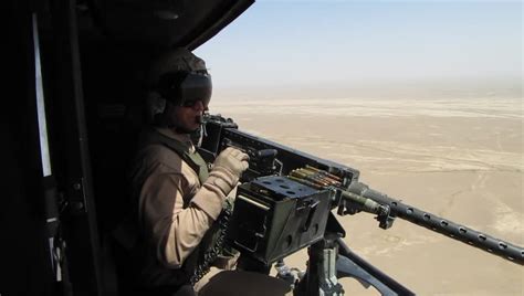 Afghanistan Circa 2010 Door Gunner Of Helicopter Fires Machine Gun At