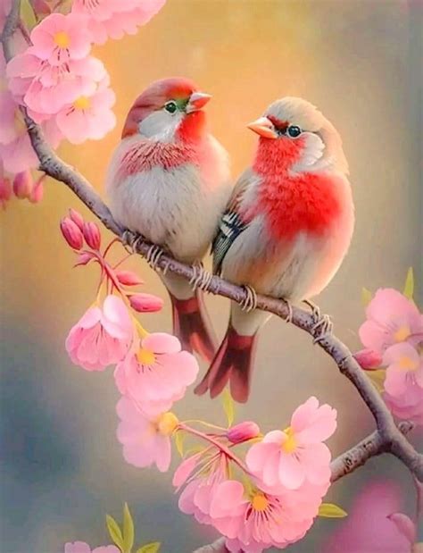 two birds sitting on a branch with pink flowers