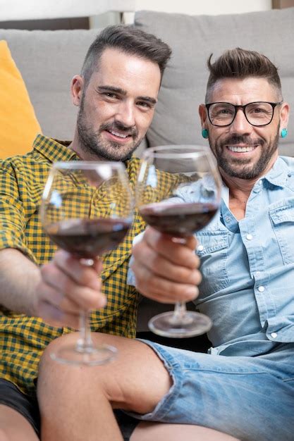 Premium Photo Gay Couple In Love Sitting At Home On The Floor And Toasting With Red Wine