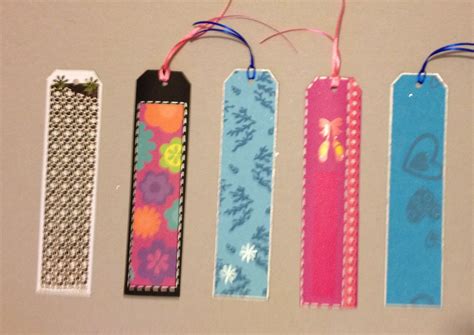 Four Colorful Bookmarks Are Hanging On A White Wall With Pink And Blue