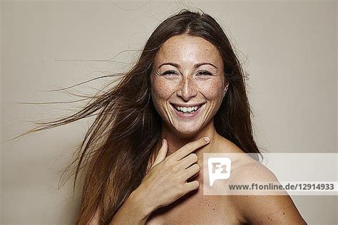 Portrait Of Freckled Young Woman With Blowing Hair Laughing