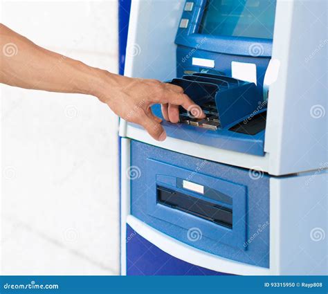 A Person Entering A Pin Number At A Blue Atm Machine Stock Photo