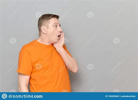 Portrait Of Shocked Man Touching Cheek With One Hand And Screaming