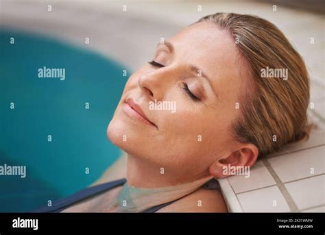 This Holiday Is Heavenly A Mature Woman Relaxing In An Indoor Swimming Pool Stock Photo Alamy