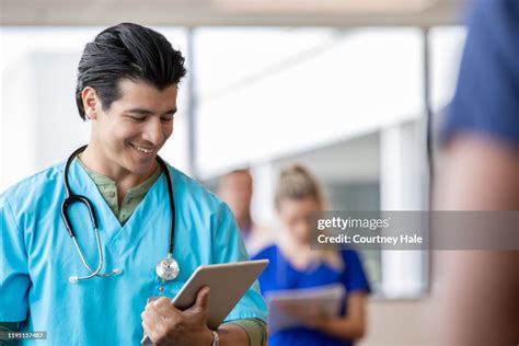 Male Nursing Student Reading Medical Records On Digital Tablet High Res