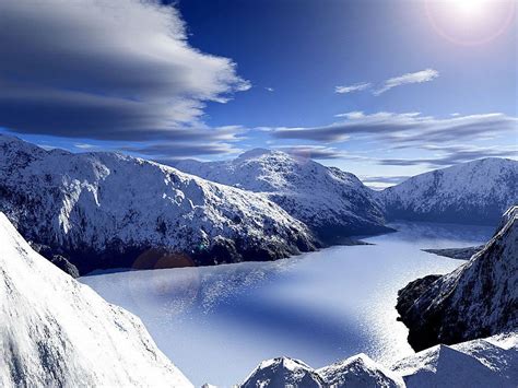 The Sun Shines Brightly Over Snow Covered Mountains And Lake In The