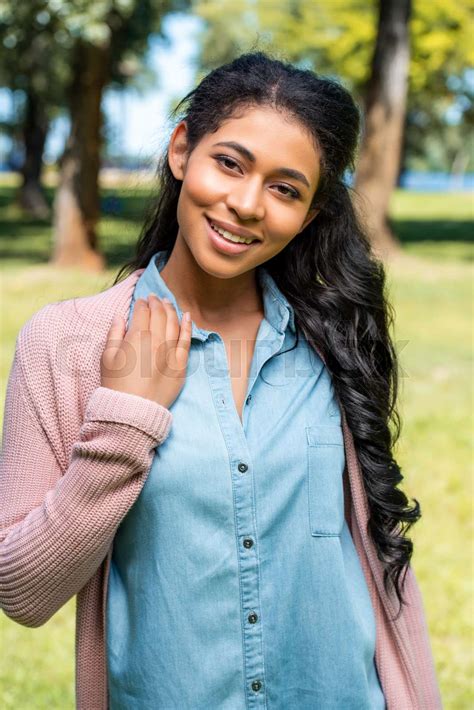 Smiling Attractive African American Woman Posing In Park And Looking At Camera Stock Image