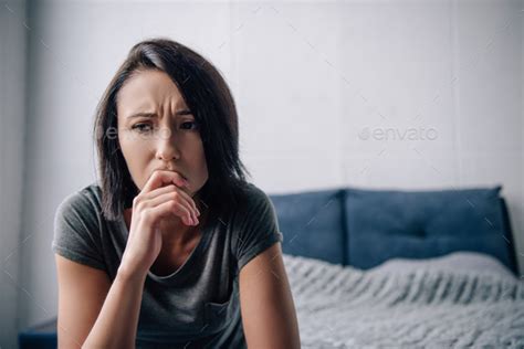 Beautiful Depressed Woman Touching Chin At Home With Copy Space Stock