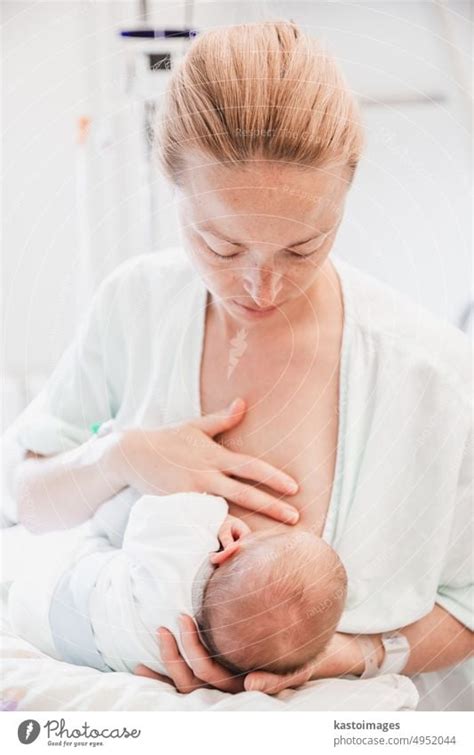 New Mother Carefully Breastfeeds Her Newborn Baby Boy In Hospital A Day
