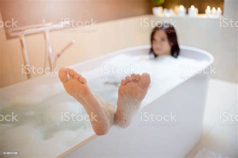 Woman Taking Bath With Her Feet On Edge Of Bathtub Stock Photo