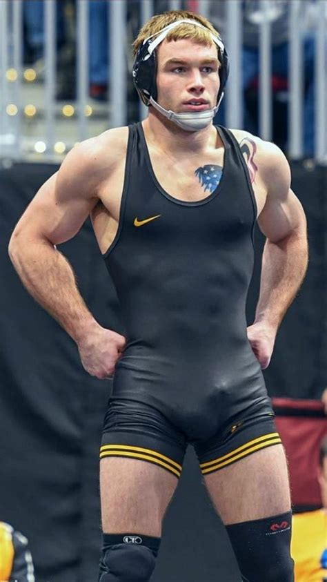 A Man In Wrestling Gear Standing With His Hands On His Hips