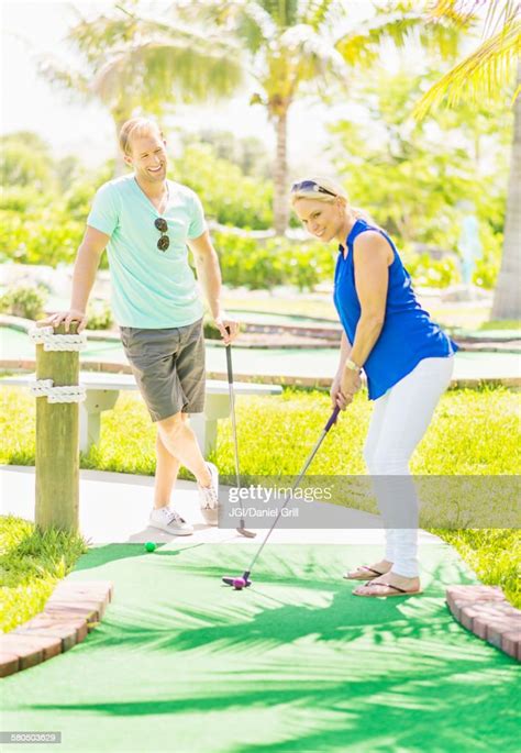 Caucasian Couple Playing Miniature Golf Photo Getty Images