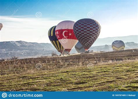 Hot Air Balloons Landing During Sunrise Flying Over Colourful Rock