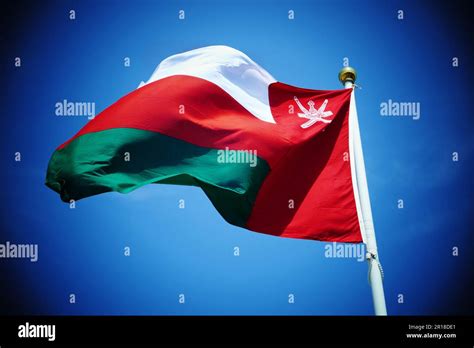 National Flag Of Sultanate Of Oman On The Flagpole Against The Blue Sky
