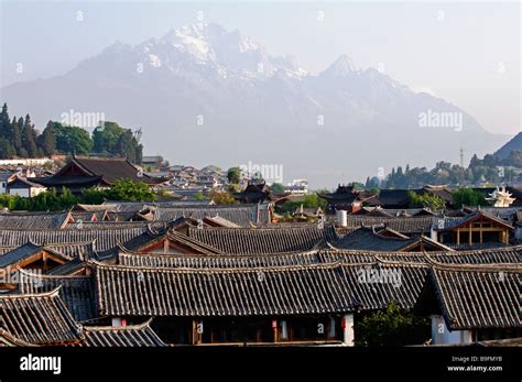 China Yunnan Province Lijiang Old Town Rooftops And Jade Peak Snow