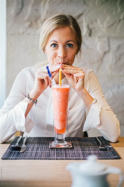 Cute Blonde Girl Drinking Smoothie In A Restaurant Del Colaborador De